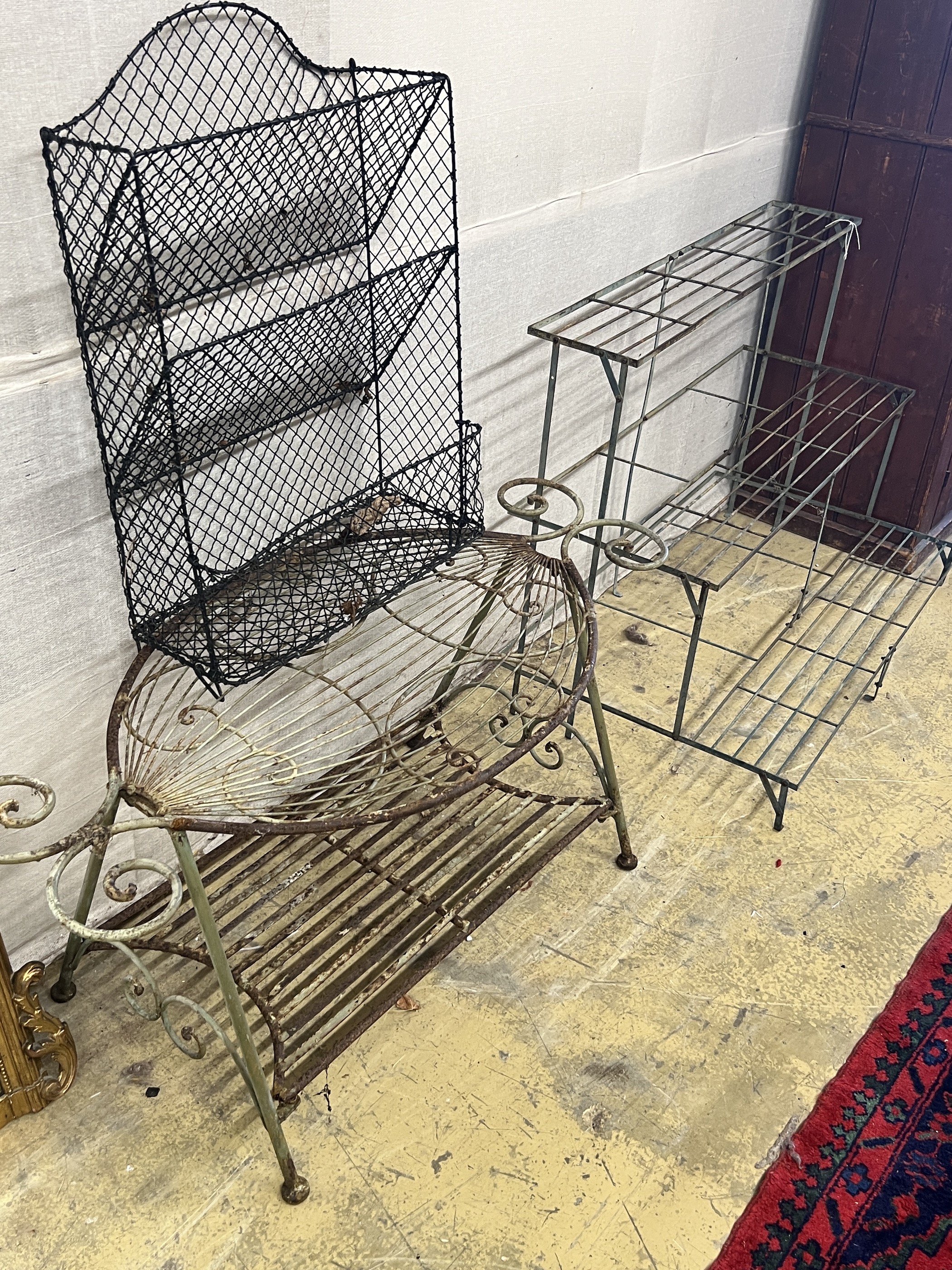 A painted wrought iron three tier pot stand, width 100cm, together with an oval wrought iron garden table and a three tier rack